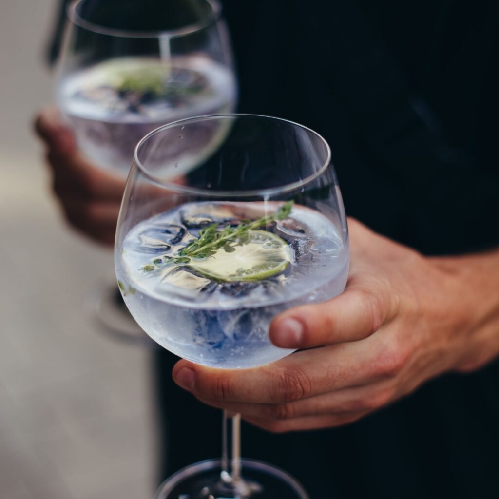 Two glasses of gin and soda with lime and rosemary — Mediterranean Gin served outdoors