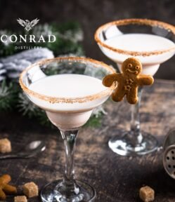 Two Gingerbread cream cocktails in sugar-rimmed glasses garnished with mini gingerbread men