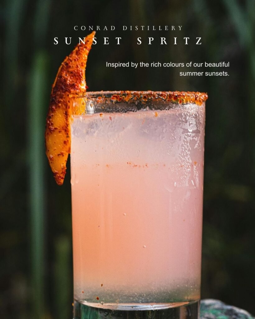Sunset Spritz cocktail made with Conrad Mediterranean Gin, served in a tall glass with spiced rim and citrus garnish.