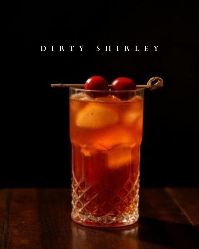 Dirty Shirley cocktail with Conrad Vodka, grenadine and ginger ale served over ice with cherry garnish.
