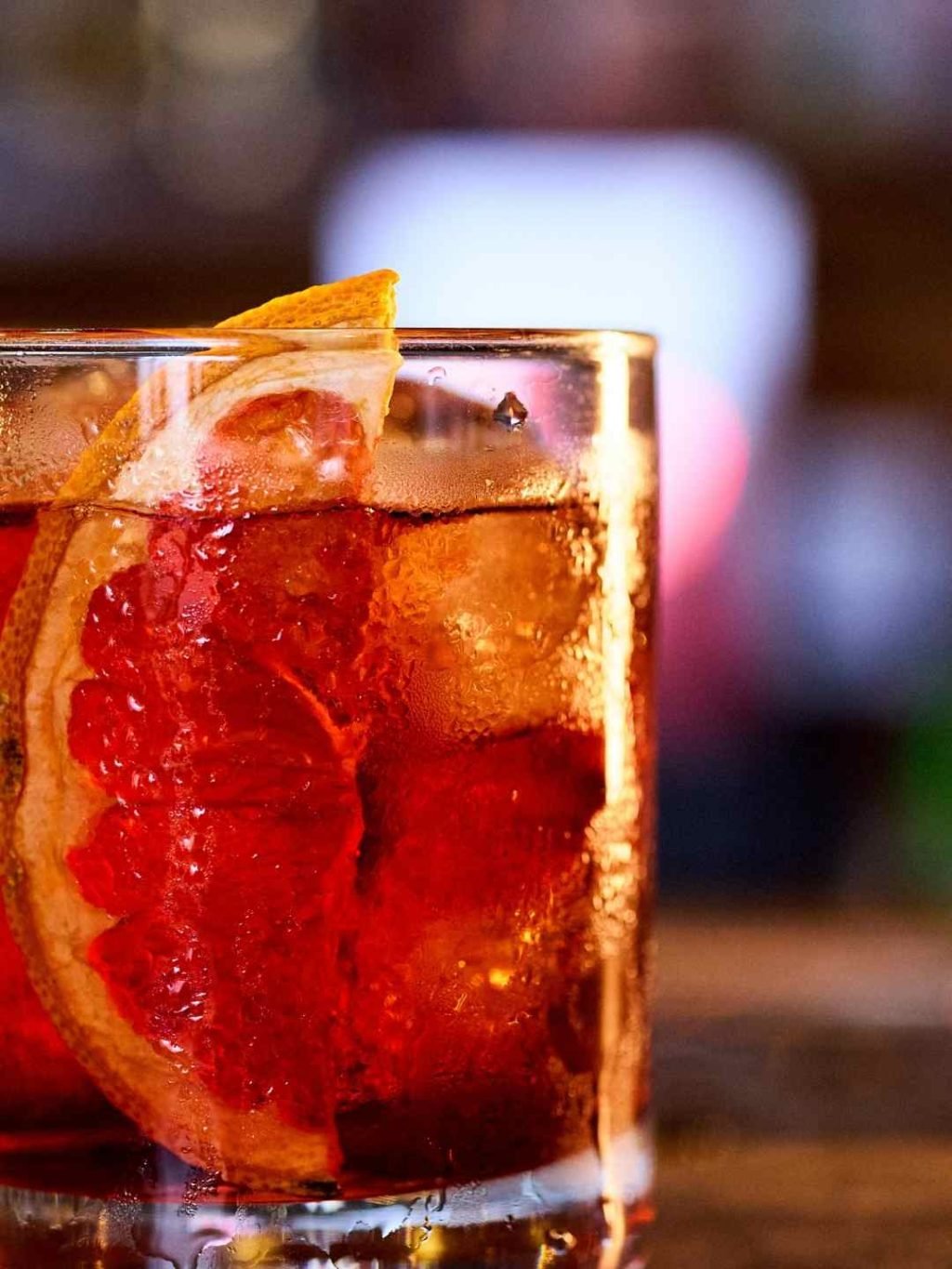 Classic Negroni cocktail served over ice with a fresh grapefruit slice garnish in a rocks glass.